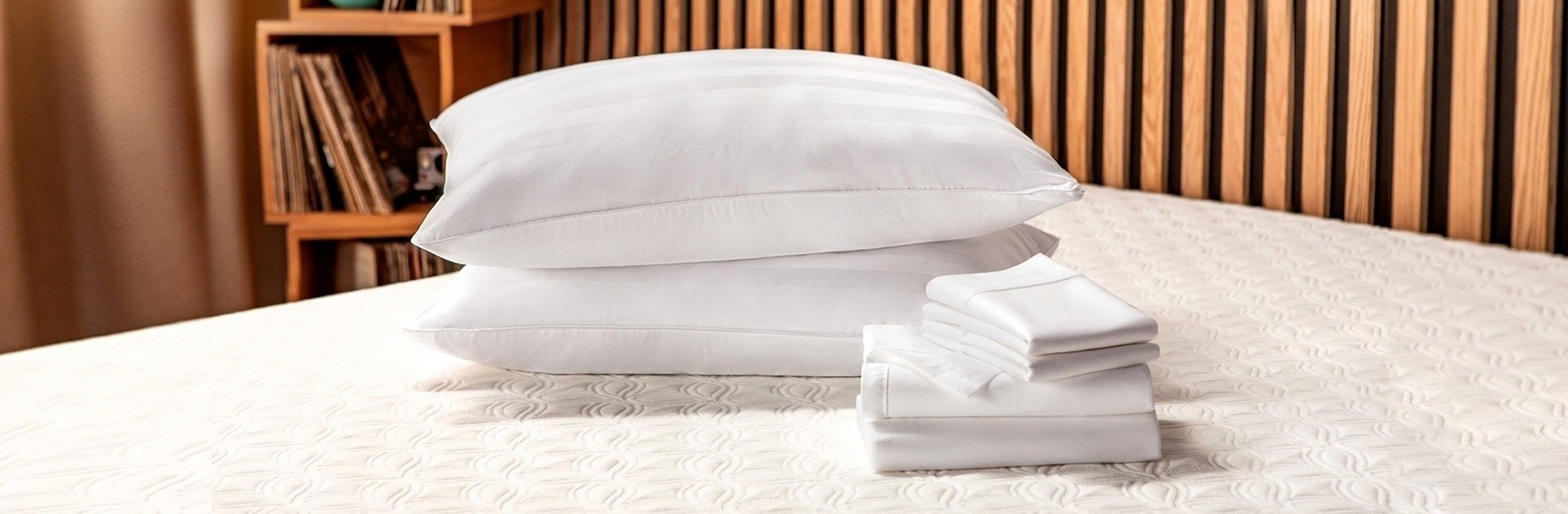 Pillows and Sheets stacked on a bed