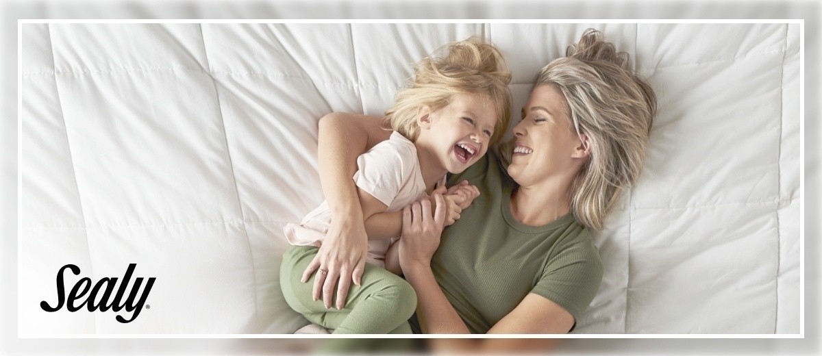 A woman and child laying on a bed