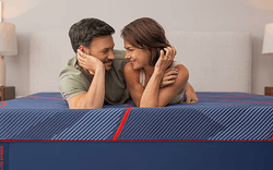 A couple laying on a Posturepedic Elite Hybrid mattress
