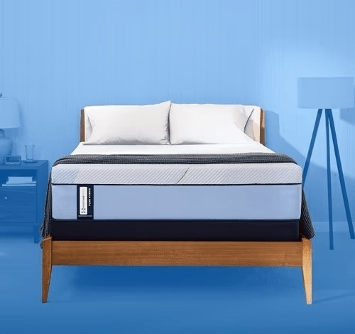 Posturepedic Plus mattress in a styled room with a blue background
